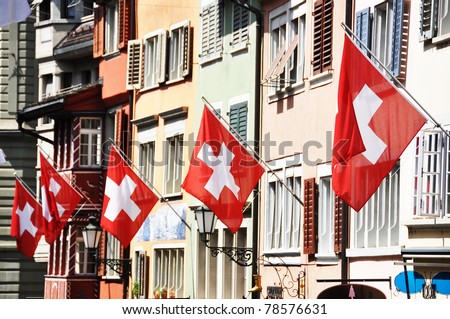 Old street in Zurich decorated with flags for the Swiss National Day, 1st of August