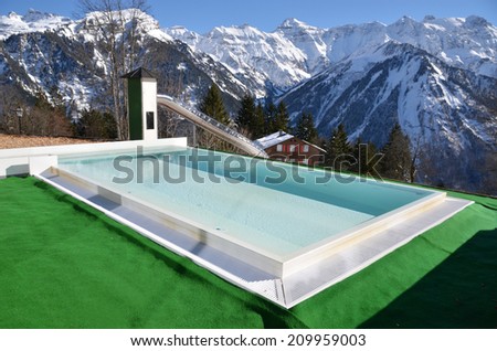 Swimming pool against snowy Alps. Switzerland