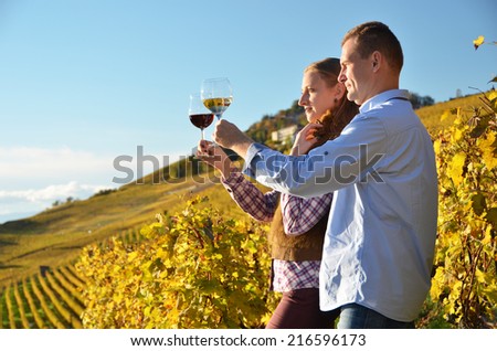 Man and woman tasting wine among vineyards in Lavaux, Switzerland
