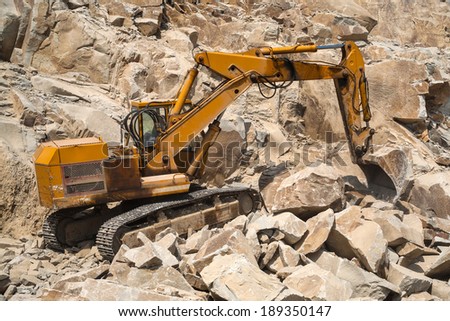 Granite quarry. Working mining machines. Mining industry.