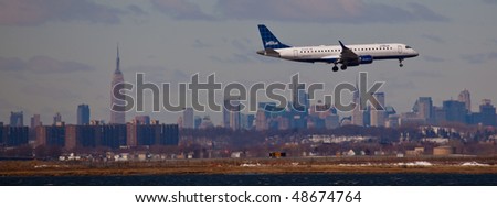 NEW YORK -MARCH 1: Airbus A320 Jet Blue airlines arriving on JFK Airport on Runaway 4L with Manhattan skyline in background on March 1, 2010 in New York. Picture taken from Bayswater Park
