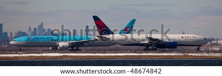 NEW YORK -MARCH 1:Two Boeings 777 getting ready for departure from JFK Airport on Runaway 4R with Manhattan skyline in background on March 1, 2010 in New York. Picture taken from Bayswater Park