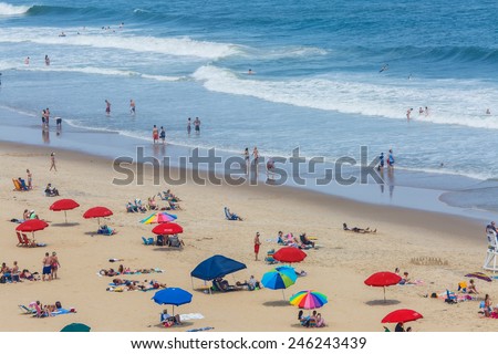 OCEAN CITY - JUNE 13: Tourists at the beach in Ocean City, MD on June 13, 2014. Ocean City, MD is a popular beach resort on the East Coast and it is one of the cleanest in the country.