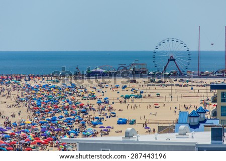 OCEAN CITY - JUNE 14: Beach full of people in Ocean City, MD on June 14, 2014 during OC Airshow. Ocean City, MD is a popular beach resorts on East Coast and one of the cleanest in the country.