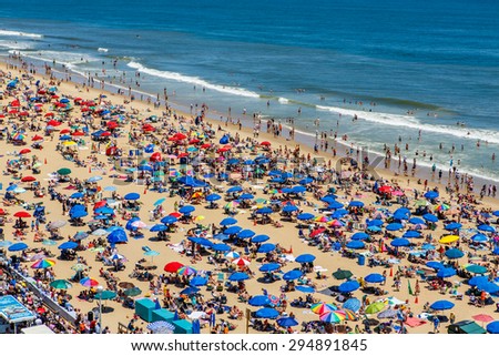 OCEAN CITY - JUNE 14: Crowded beach covered with umbrellas in Ocean City, MD on June 14, 2014. Ocean City, MD is a popular beach resort on the East Coast and one of the cleanest in the country.