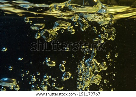 closeup colored    bubbles in   water on a dark background