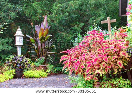 Driveway with flower bushes and cross sign