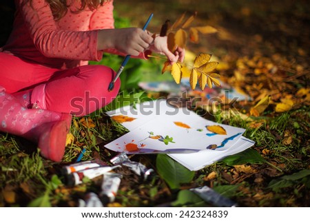 Child drawing  in Autumn Park. Creative kids development concept.