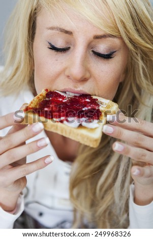 Young woman eating marmalade toast. Selective soft focus