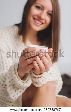 Soft photo of woman with  cup of coffee in her hands.  Selective soft focus