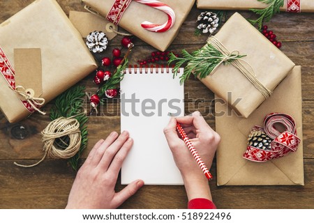 Christmas letter writing on paper on wooden background with decorations