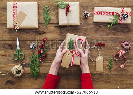 Woman holding in hands christmas present with red ribbon. Xmas concept. Eye bird view.
