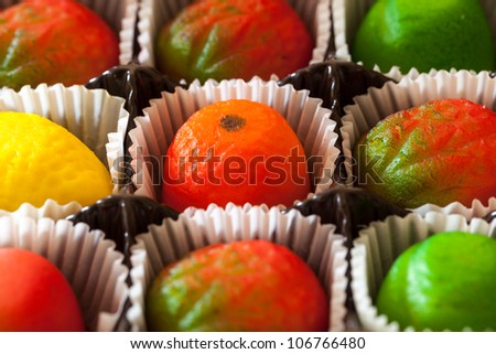 Fruit shaped candies in macro image of marzipan sweets in paper wrappings