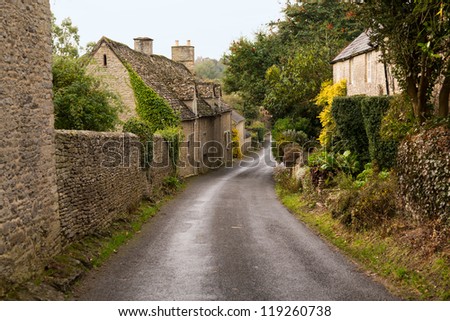 Narrow lane in vilalge of Minster Lovell in Cotswolds with stone cottages