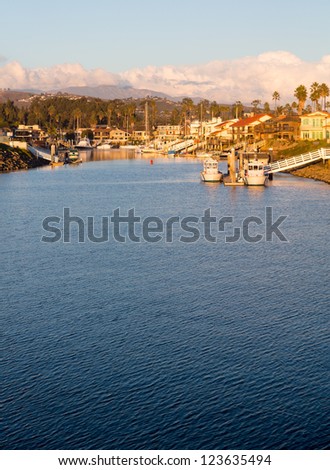 Sunset over residential development by water in Ventura California with modern homes and yachts boats