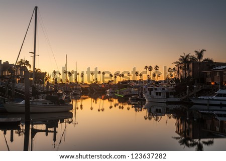 Sunset over residential development by water in Ventura California with modern homes and yachts boats