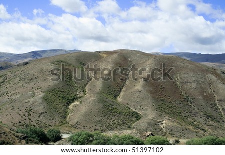 Rolling countryside valley in New Zealand with valleys cut into the hillside