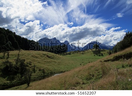 Rolling countryside valley in New Zealand with folded hills and mountains