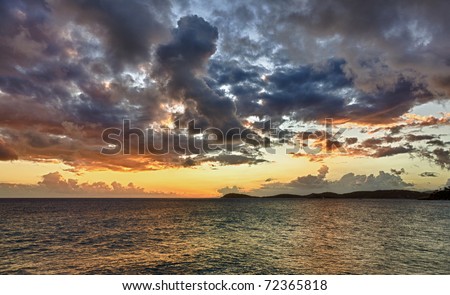 HDR impression of a sunset over the ocean with a distant island on the horizon
