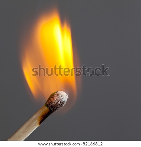 Green coated match head starts to burn with light blue smoke
