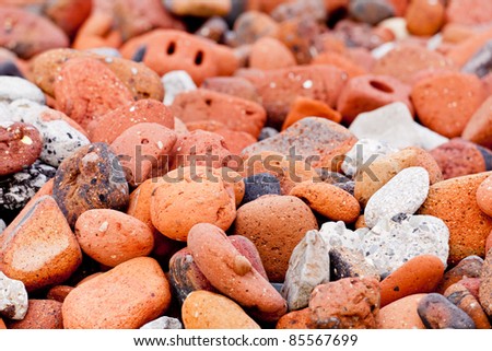 Sea worn pebbles and bricks form a sea wall on beach