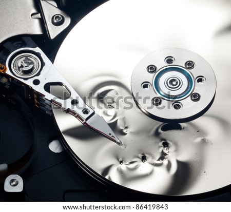 Magnetic disc inside a computer hd unit showing damage to the mirror surface of the magnetic discs and read write head