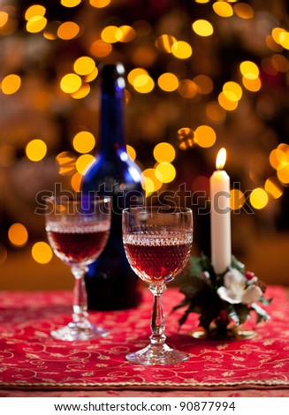 Cut glass sherry or port glasses in front of an out of focus christmas tree with blue bottle
