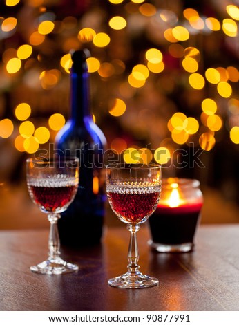Cut glass sherry or port glasses in front of an out of focus christmas tree with blue bottle