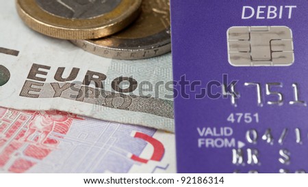Macro of debit card and on top of euro note to illustrate currency crisis in Europe