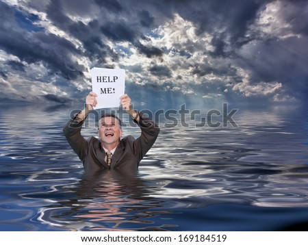 Conceptual image of senior businessman in suit up to waist in deep water worried about drowning in paperwork and holding help me document. Stormy clouds behind reflect in the ocean.