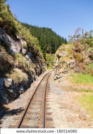 Railway track of Taieri Gorge tourist railway cuts through a narrow cutting in the rocks on its journey up the valley