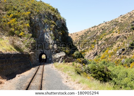 Railway track of Taieri Gorge tourist railway runs into a tunnel on its journey up the valley