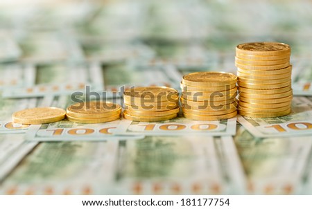 Stack of golden eagle coins in rising price graph or bar chart and standing on new design of US currency one hundred dollar bills