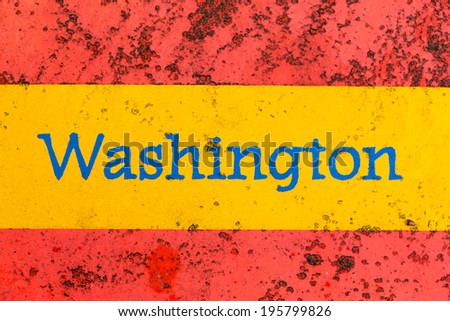 Detail of the word Washington on a newspaper stand that is brightly painted but starting to rust