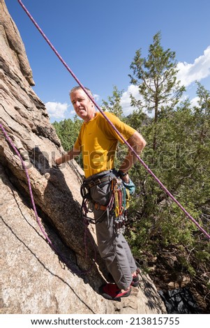 Senior male climber well equipped with cams and caribiners on Turtle Rocks near Buena Vista Colorado