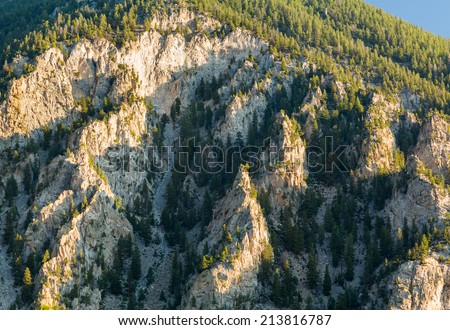 Steep jagged spikes of  chalk white cliffs of Mount Princeton near Buena Vista in Colorado shortly after sunrise as the sun first lights the mountainside