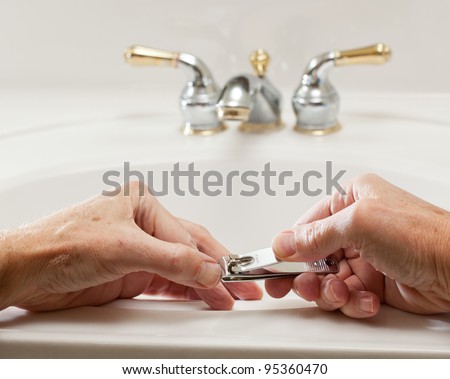 Finger nail clippings in palm of hand on bathroom sink