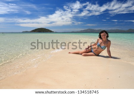 Young woman in bikini laying on the beach