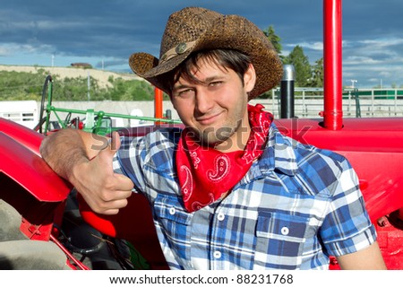 Portrait of smiling tractor driver wearing cowboy hat, silk scarf, and checked shirt. Calgary Stampede 2011, Alberta, Canada