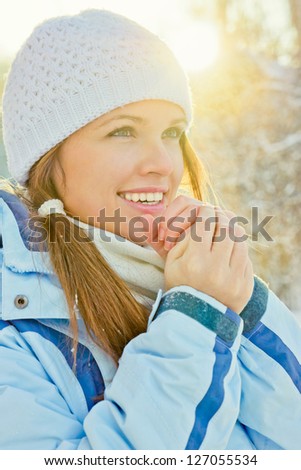 Outdoor photo from a beautiful young woman in warm clothes, sunset in the background/Winter sunset portrait