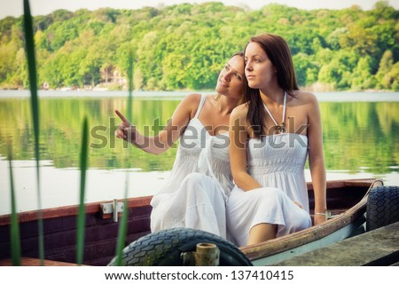 Two beauty\'s one boat / Two young woman sitting on a boat and watching something