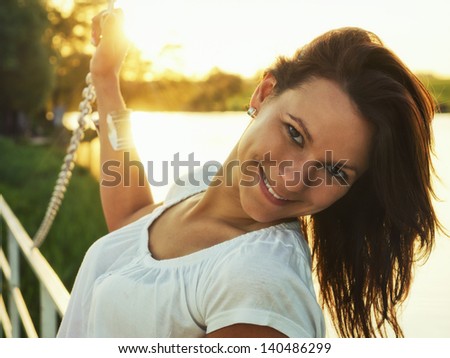 Happy sunset / Cheerful woman standing on a small bridge, with a sunset in the background