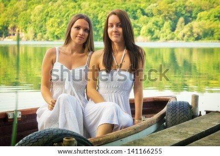 Two beauty\'s one boat / Two beautiful young woman sitting on a boat