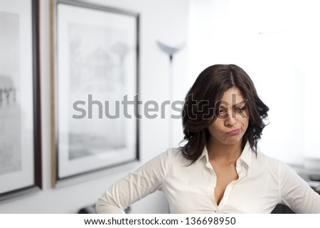 young confused business woman posing on office background