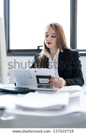 young business woman reading a paper on office background