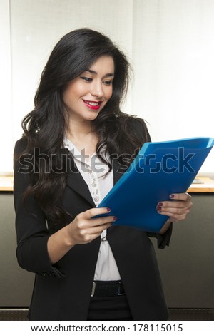 Young smiling fashion business woman holding a notebook on white background