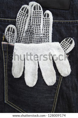 Working glove in the back pocket of old used jeans