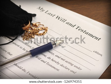 Last Will and Testament form with gold jewelry, close-up