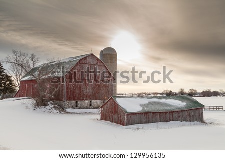 Old winter barn on snow covered farm field in northern Ontario.