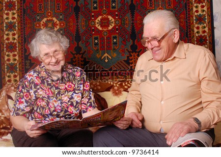 senior couple read the news and smile